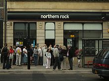 A number of people queuing at the door of a branch of the Northern Rock bank.