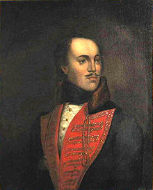 Picture of a painting of a man with a mustache wearing a red V collar; the man is slightly bald, and looking to his left.