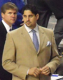 A Hispanic man in his thirties wearing a suit