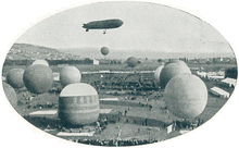 An airship floating behind a number of balloons in the foreground