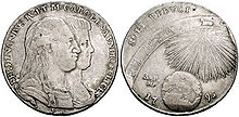 Two heads appear on a grey coin surrounded by Latin text