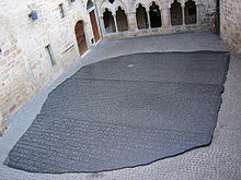 "Photo depicting a large copy of the Rosetta Stone filling an interior courtyard of a building in Figneac, France"