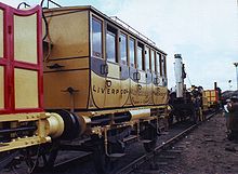 Ornate railway carriages and a small yellow locomotive