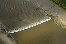 A tidal bore wave moves along the River Ribble between the entrances to the Rivers Douglas and Preston.