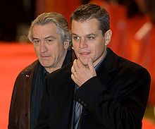  Photo of Damon and De Niro, each wearing a tuxedo jacket and a dark blue shirt.