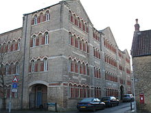 Corner of four storey building with multiple matching arched windows