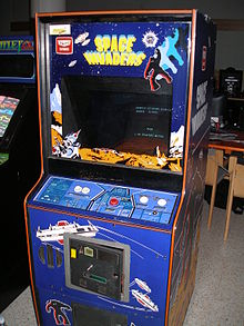 A blue arcade cabinet with a screen surrounded by decals. The game controls sit below the screen.