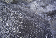A photograph of dark gray/silver piles of spent shale lumps.