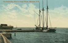 A large vessel floats beside a dock.