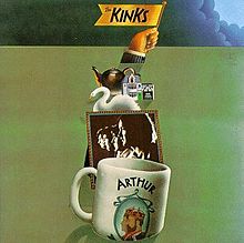 The front cover artwork of the album. A white coffee mug with the word "Arthur" and a picture of two men sits in the foreground; a sepia-tone profile photo of The Kinks sits behind it; a swan and other small, various objects sit behind the photo. A hand raises a flag from behind the pileup, which reads "The Kinks". These objects sit on a green background, with the exception of the top border, which is covered by storm clouds.