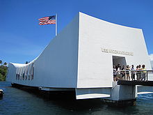 white rectangular memorial building with U.S. flag flying above
