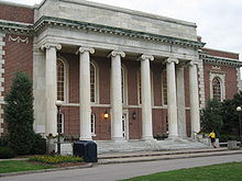 A large Georgian-style building exterior with six Ionic Columns and red brick with large arched windows