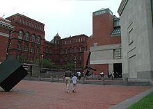 Raoul Wallenberg Place Entrance of USHMM. Three large façades made of brick and limestone. In the foreground a black modern art statue.