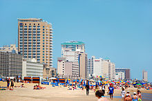 High-rise hotels line the ocean front covered with colorful beach-goers.
