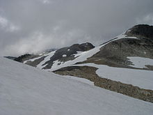 Rugged landscape of rock covered with snow on a cloudy day.