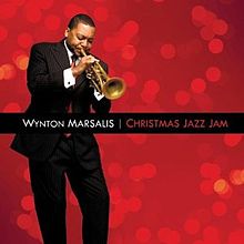 Before a red background, a man in a suit is playing a trumpet with his eyes closed; the text "Wynton Marsalis