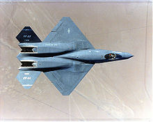 Top view of black jet aircraft, showing trapezoidal wings, engine nozzle, and two-piece tail. The separation between the forward fuselage and engine nacelles are apparent.