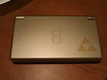 A gray handheld video game device with the Triforce logo in the bottom-right corner, which looks like three triangles touching at their points.