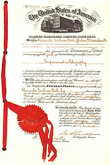 An official government patent document, with a red ribbon and legal seal attached to its left margin.