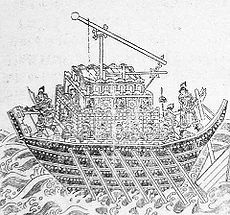 An illustration of a short, wide ship propelled by seven rowers per side. The entire surface area of the deck is occupied by a trebuchet, with a small area in the front for two archers and a small platform in the rear for one man to hold a rod controling the vessel's rotor.