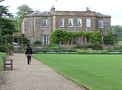Large house with terrace and lawn.