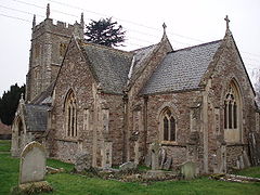 Stone building with square tower and arched windows.
