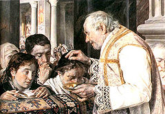 A priest sprinkles ashes on the heads of worhsippers.