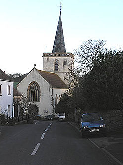 White painted church with square tower topped with a spire.