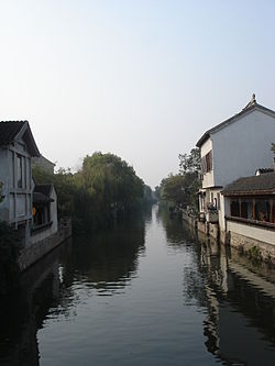 Looking down a canal in Mudu, buildings are on the left and right