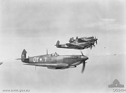 Five single-engined World War II-era monoplanes flying parallel to one another