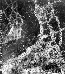 An aerial reconnaissance photograph of the opposing trenches and no-man's land between Loos and Hulluch in Artois, France, taken at 7.15 pm 22 July 1917. German trenches are at the right and bottom, British trenches are at the top left. The vertical line to the left of centre indicates the course of a pre-war road or track.