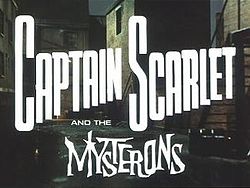 In bold, white letters, the words "Captain Scarlet" are superimposed on the backdrop of a derelict, night-time alleyway. Added at the bottom of the picture are more words, "and the Mysterons", the last of which is in white, spiky lettering. The full title is thus revealed to be "Captain Scarlet and the Mysterons".