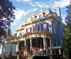 Front view of Chichester House, mottled by sun and shadow from nearby tree