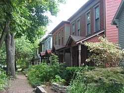 A view of the Cottage Home Historic District from Dorman Street. Two historic homes and a historic sidewalk can be seen.