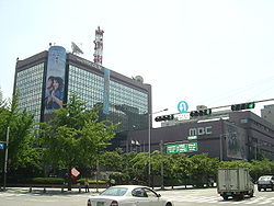 Four-story MBC headquarters, with trees in foreground