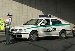Older-model police car, white with green horizontal stripe