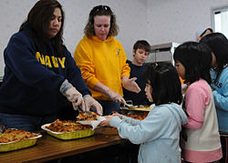 US Navy 110327-N-MU720-031 Volunteers erve food to children at the Biko-en Children's Care House.jpg