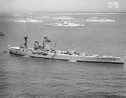 Photo showing a battleship in the foreground and more battleships and cruisers in the background