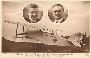 Faded brown postcard with a photograph of a white biplane.  Two oval cameo pictures are above the plane, showing the faces of two men.  On the left, is a clean-shaven healthy-looking man in his mid-30s, with a pilot's squint.  On the right, is a man that's slightly more heavyset, with a black eyepatch over his right eye