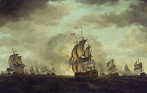 An oil painting depicting a sea battle. The sky has dark clouds with patches of blue, and the sea is grey. Warships are visible in the distance, some of which are exchanging cannonfire.  A British warhip occupies the center foreground, obscuring an explosion behind it.