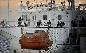 A chemical tanker with South Korean naval personnel in full combat gear onboard; the tanker shows signs of a fight with broken glass and holes in the windows.