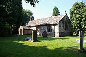 A simple low church with a south porch.  On the west gable is a bellcote, and on the east gable is a cross