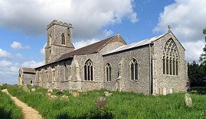 A stone church seen from the southeast, showing the chancel, beyond which is a taller nave with a south aisle and porch, and a battlemented tower