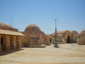 Rocky buildings and an antenna-like structure in a desert.