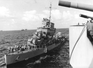 The USS Rowan receiving provisions via "high-line" from USS Augusta (CA-31) while operating at sea, 4 December 1942.
