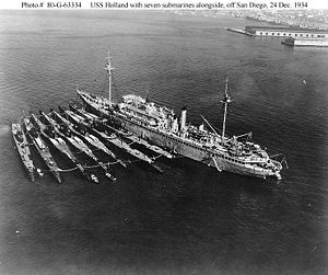 Seven V-boats (from left to right: Cachalot, Dolphin, Barracuda, Bass, Bonita, Nautilus, Narwhal, with submarine tender Holland.