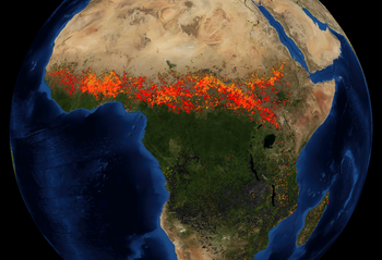 An artificially coloured satellite view of Africa, with red and yellow markers where fires have been detected. A wide red band of markers runs east-west, just south of the Sahara Desert.