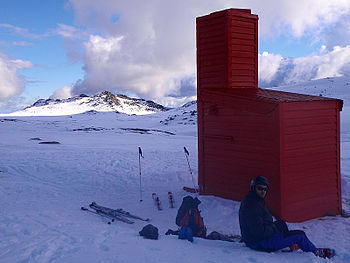 A skier talks rests outside Cootapatamba Hut, late September 2010. Image by Leigh Blackall
