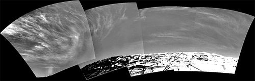 A composite black-and-white photograph showing cirrus clouds over the surface of Mars.