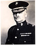 an image of a white male in his military uniform with a hat on and a mustache. Military style ribbons are clearly visible.